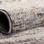 Close-up of the Boho Mirage Rug showing its soft polyester fibers, intricate weave, and earthy tones of beige, blue, and brown.
