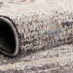 Close-up of the Boho Mirage Rug showing its soft polyester fibers, intricate weave, and earthy tones of beige, blue, and brown.