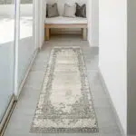 Mist Haven Rug runner with a distressed gray and cream design, styled in a minimalist hallway with natural light and soft furnishings.