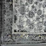 A luxurious black and gold Persian carpet with intricate floral patterns, perfect for modern interiors.