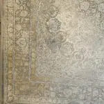A detailed view of the Emir Carpet’s corner and border, featuring intricate floral motifs with antique gold and silver accents.