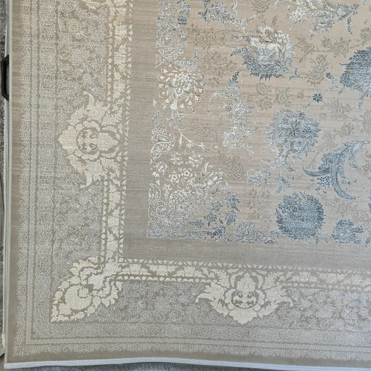 A close-up of the Imperial Carpet’s elegant border, featuring intricate floral motifs in Antique Beige and Royal Blue.