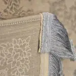 Close-up of the Imperial Carpet’s fringe and border, showcasing intricate weaving in soft Antique Beige and Ivory tones.
