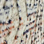 A side-angle close-up of the Kazakh Rug, highlighting its high-pile texture, warm earthy tones, and distressed Bohemian-inspired pattern.