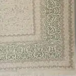 Close-up of the Kuwait Carpet’s intricate Persian border, featuring elegant floral motifs, a distressed neutral tone, and luxurious weaving for wholesale buyers and high-end interiors.