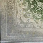 A close-up of the Majestic Carpet’s intricate border, featuring an elegant gradient from green to silver with ornate floral motifs and vintage Persian detailing.