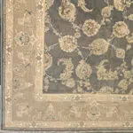 A close-up of the Malik Carpet’s intricate corner and border design, featuring floral motifs in beige, navy blue, and soft pastels. This 1200 reeds carpet blends traditional elegance with modern luxury.