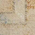 Close-up of the Nomad Haven Rug, highlighting its textured weave, intricate patterns, and warm-toned color palette with soft blue, beige, and rust accents.