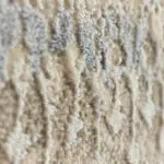 A macro close-up of the Samarkand Carpet’s soft, high-low textured pile in beige and blue tones, highlighting its intricate distressed Persian-inspired pattern.