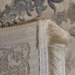 A close-up of the Seraphic Carpet’s elegant beige fringe and durable backing, showcasing fine craftsmanship and premium finishing.