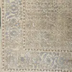 A close-up of the Seville Moorish Carpet’s intricate floral border, featuring Persian-inspired motifs in soft beige and blue hues.