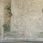 Close-up of Sultan Carpet’s intricate border with floral scrollwork in beige, green, and ivory, featuring a luxurious fringe.