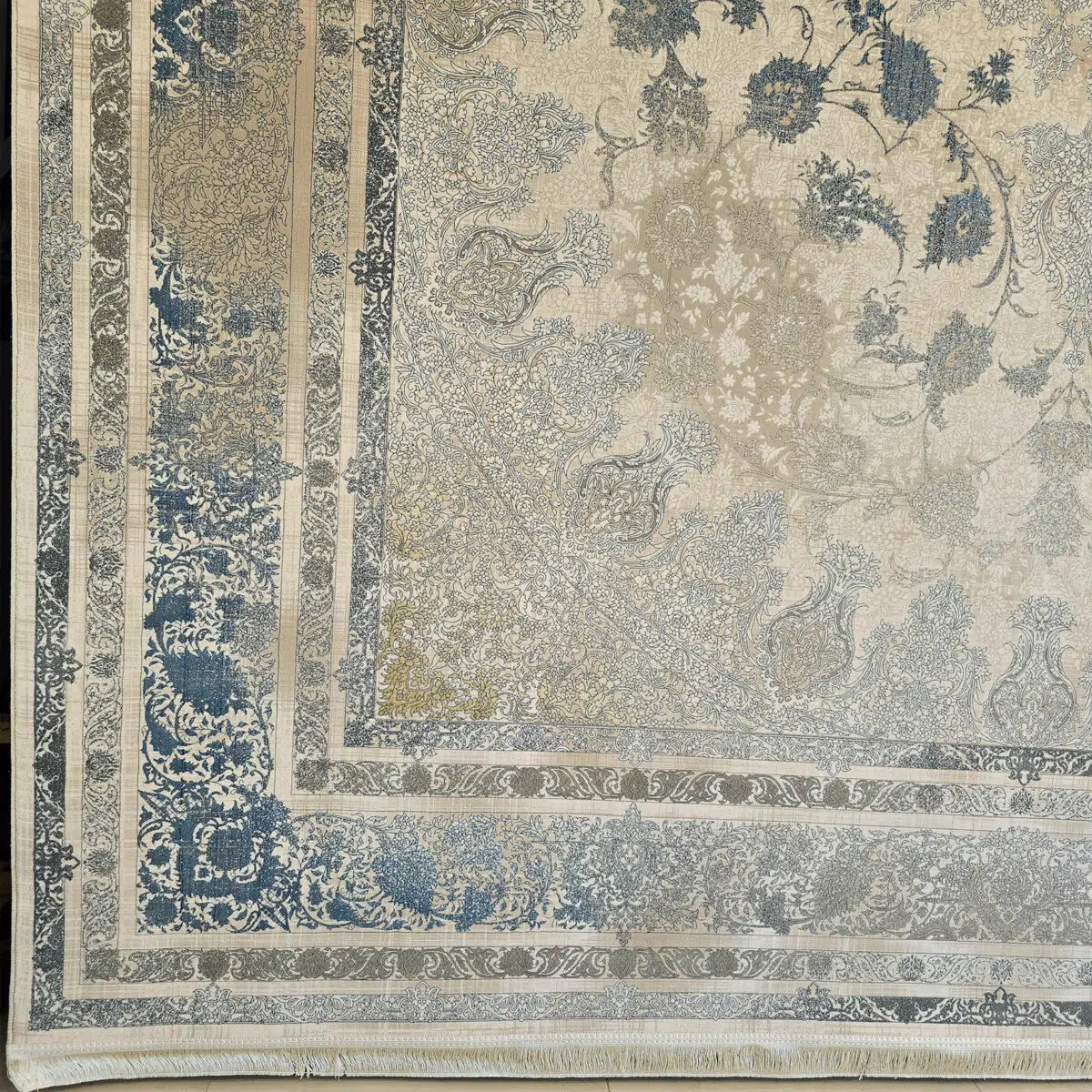 Close-up of the Sultan Qaboos Rug’s intricate border, showcasing floral motifs and fine craftsmanship in beige, gold, and blue tones.