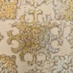 A detailed close-up of the Versailles Elegance Carpet, showcasing its plush high-low texture, intricate medallion detailing, and elegant gold and beige floral patterns. This premium 480 reeds Persian carpet is designed for luxury interiors, royal residences, and high-end wholesale buyers in the Gulf region.