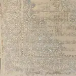 A close-up view of the Versailles Elegance Carpet’s intricate floral border and Persian-inspired detailing, featuring delicate vine motifs, classic beige and gold hues, and soft distressed textures. This luxury Persian carpet is crafted for wholesale buyers, luxury residences, and premium interior design projects.