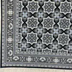 High-resolution close-up of the geometric star pattern on the Kuwait Royal Carpet, featuring black, ivory, and gold tones.