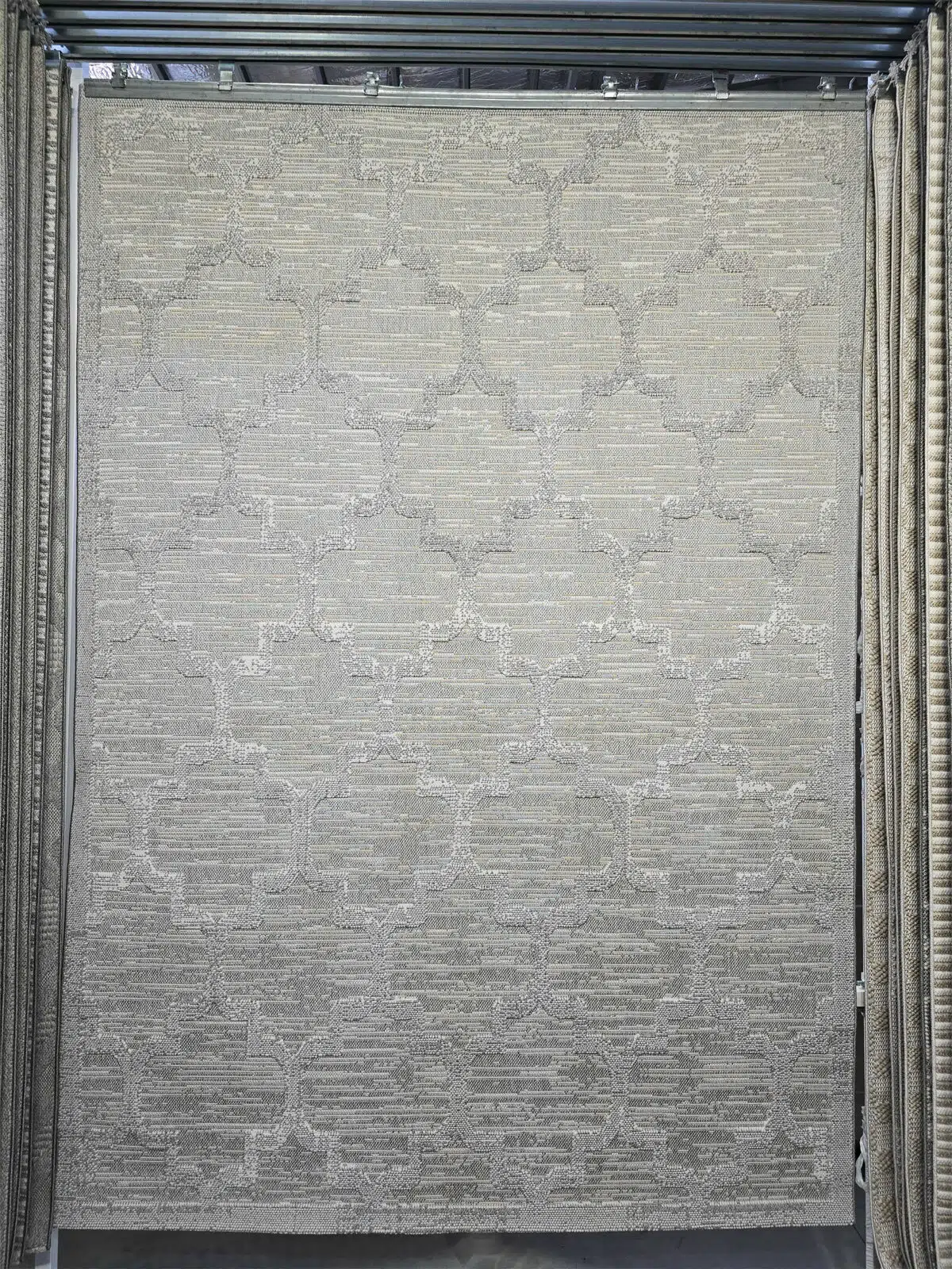 Full view of Twilight rug featuring soft geometric lattice pattern in beige and silver tones