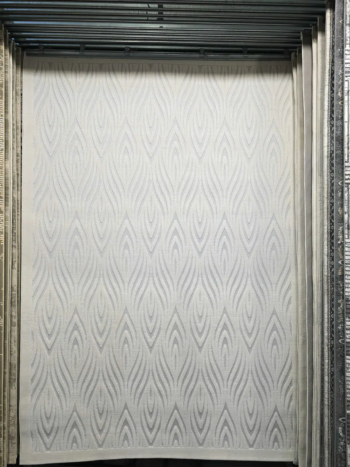 Full front view of Titan rug with organic wave or flame-like motifs in soft white