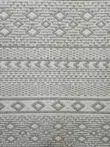 Zoomed-in view of the diamond and chevron motifs on Equinox rug in light grey and ivory