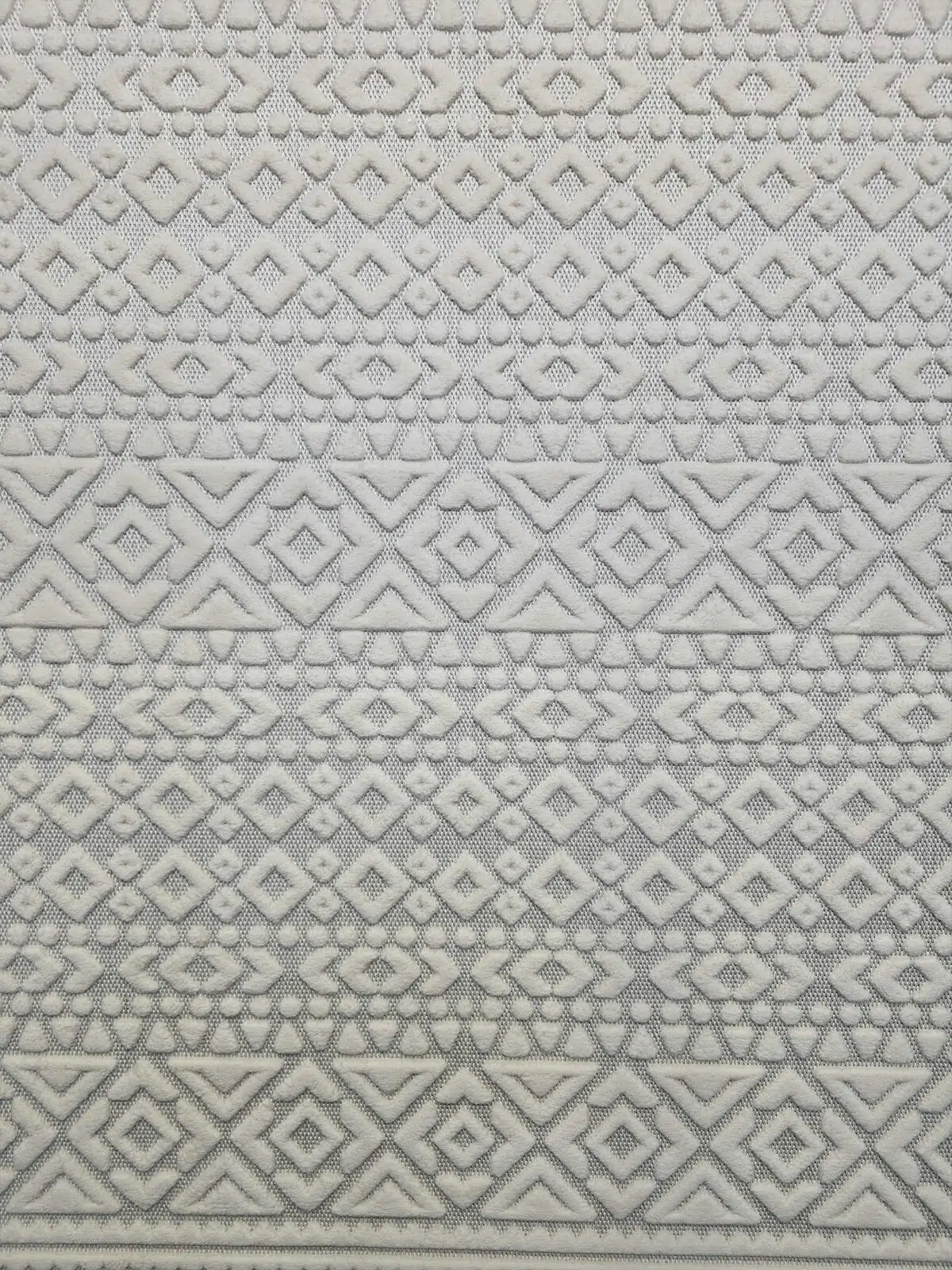 Close-up shot of Nova rug’s detailed white embossed diamond textures