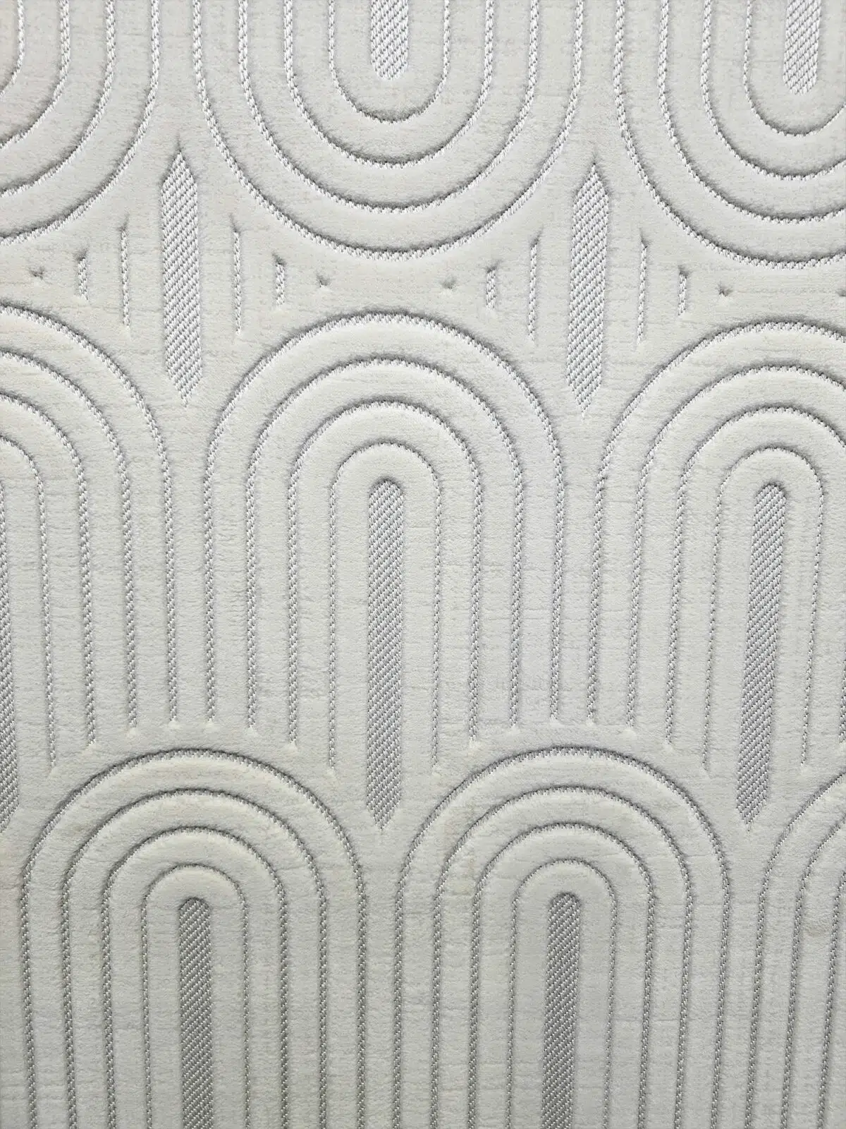 Mid-close detail of the Orion rug showing layered arched lines and soft surface