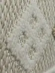Slanted close view of ivory diamond motif in Radiant rug