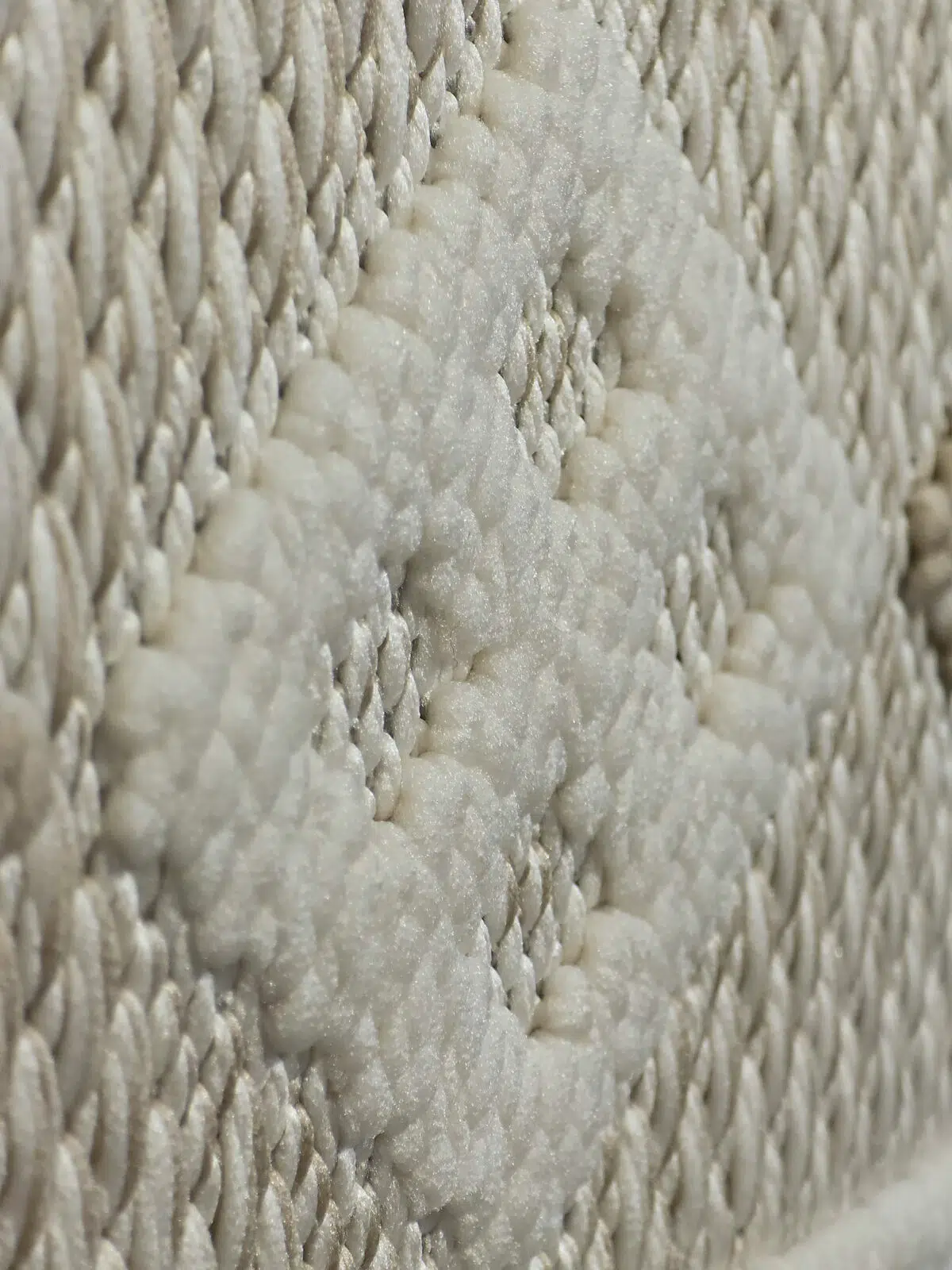 Slanted close view of ivory diamond motif in Radiant rug