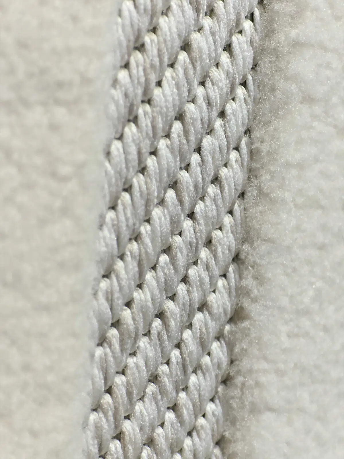 Yarn texture and weaving details of the Orion rug in soft white fibers