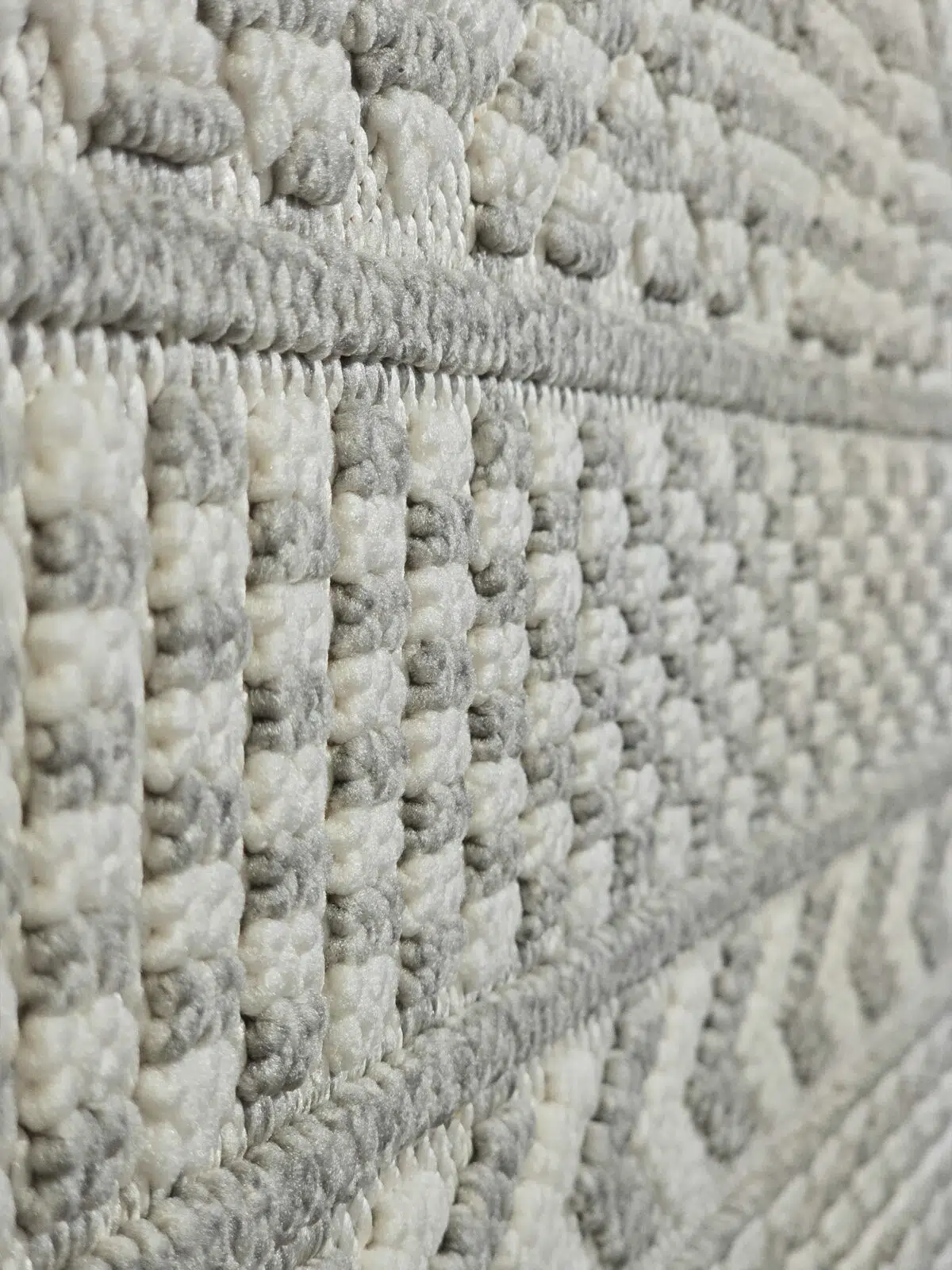 Macro view of vertical woven bands and grey-white squares on the Equinox carpet