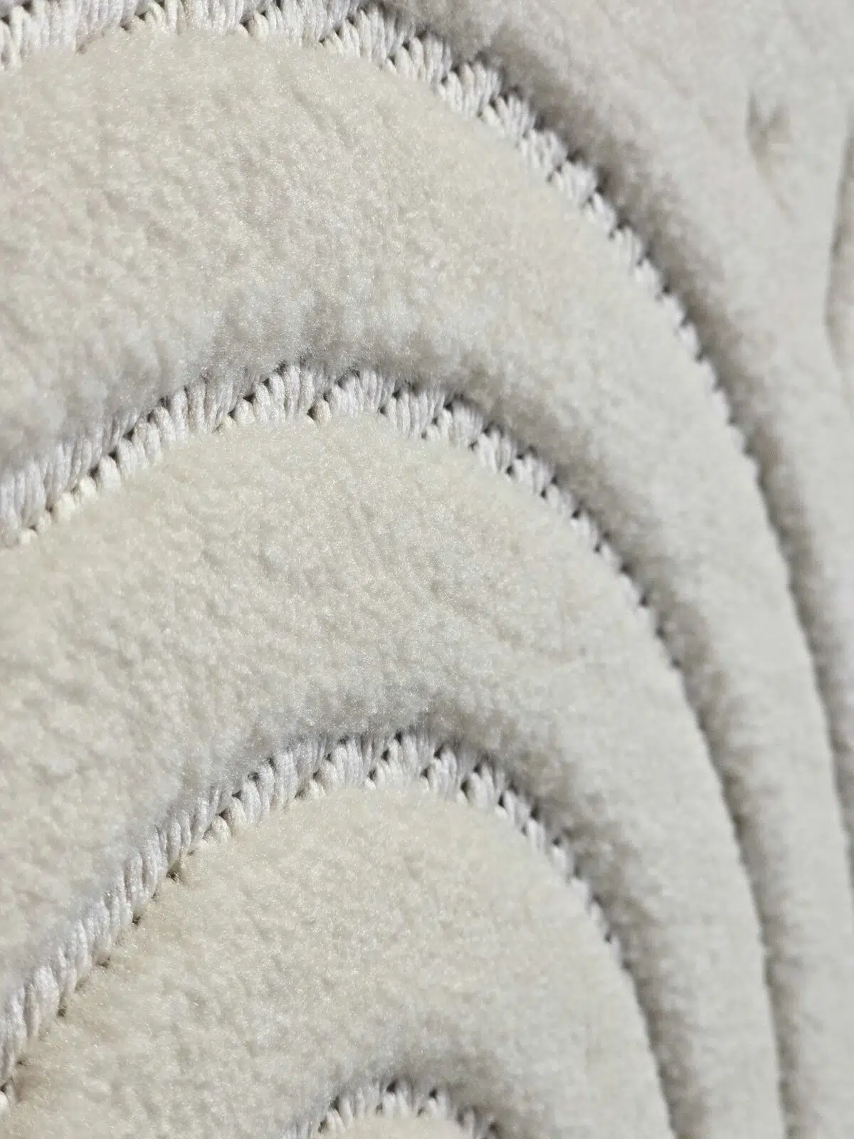 Side texture of the Orion rug showing plush curved lines and smooth surface