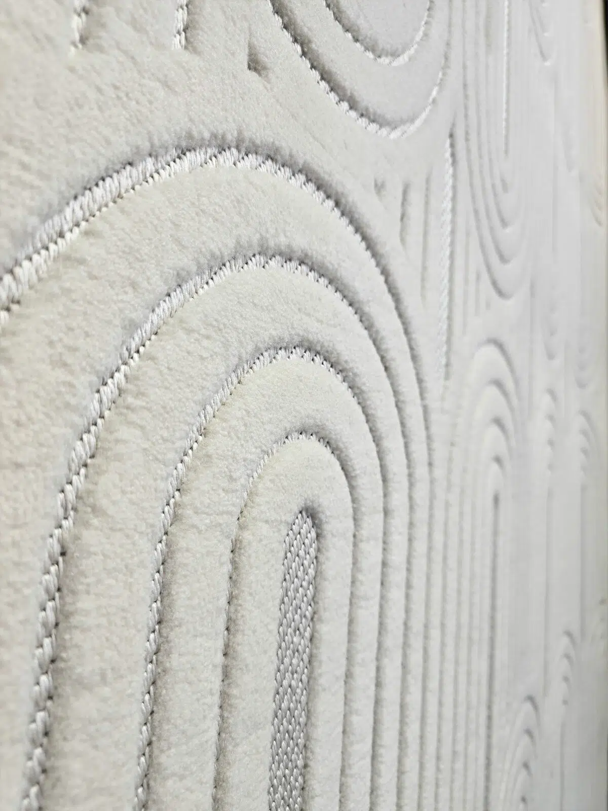 Wide side angle of Orion rug showing repeating arches and soft texture