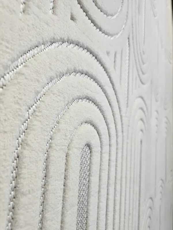 Wide side angle of Orion rug showing repeating arches and soft texture