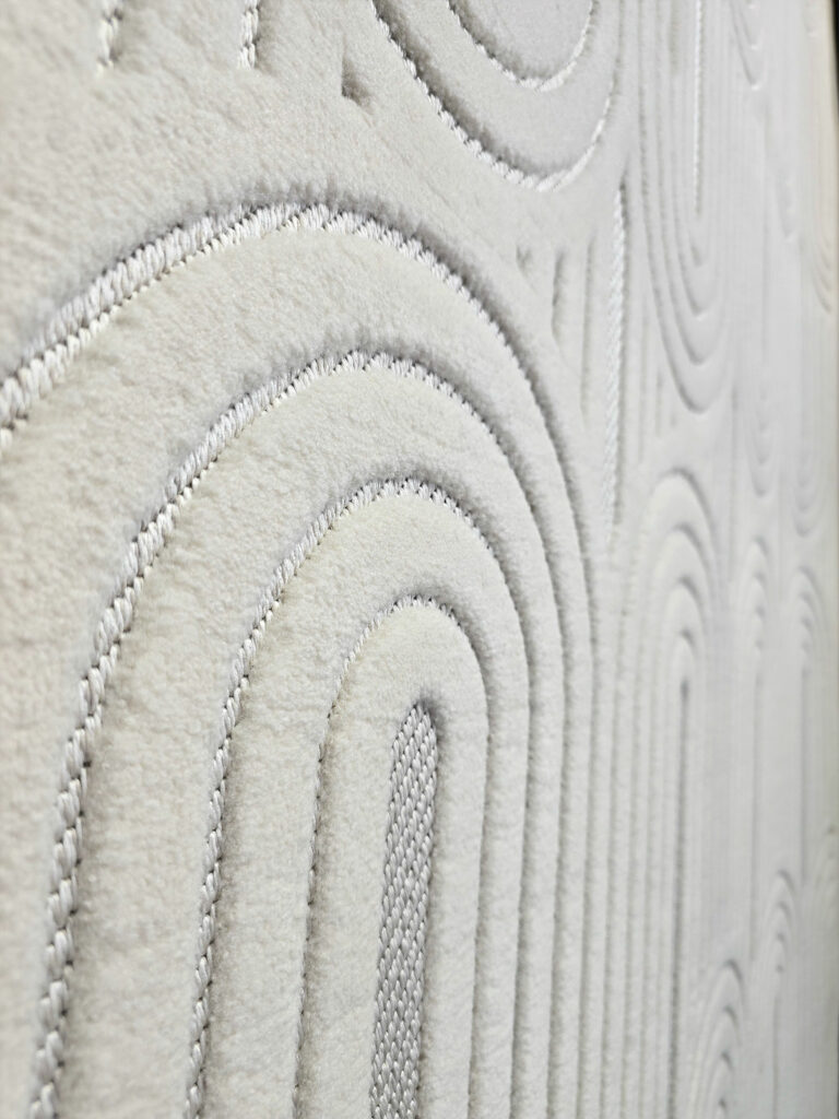 Wide side angle of Orion rug showing repeating arches and soft texture
