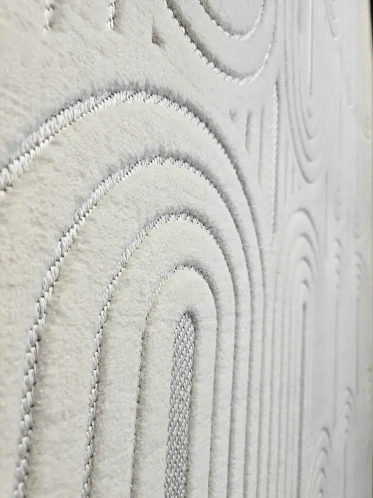 Wide side angle of Orion rug showing repeating arches and soft texture