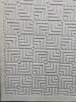 Angled photo showing the geometric grid pattern of Lyra rug