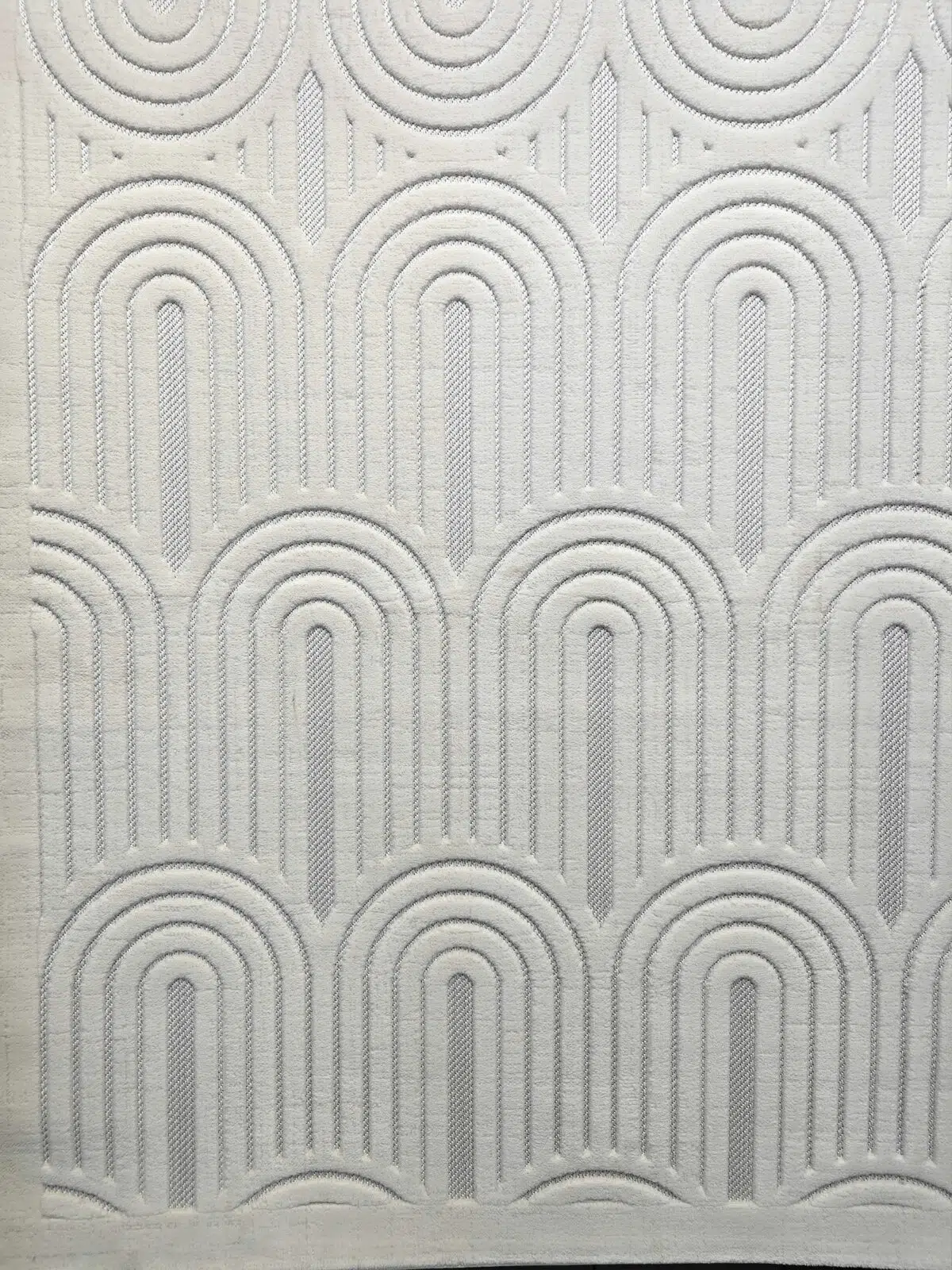Lower part of Orion rug showcasing elegant curved lines in soft white