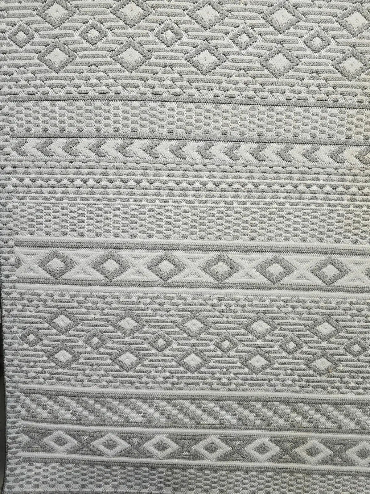 Extreme close-up of Equinox rug’s looped weave with grey and white yarns