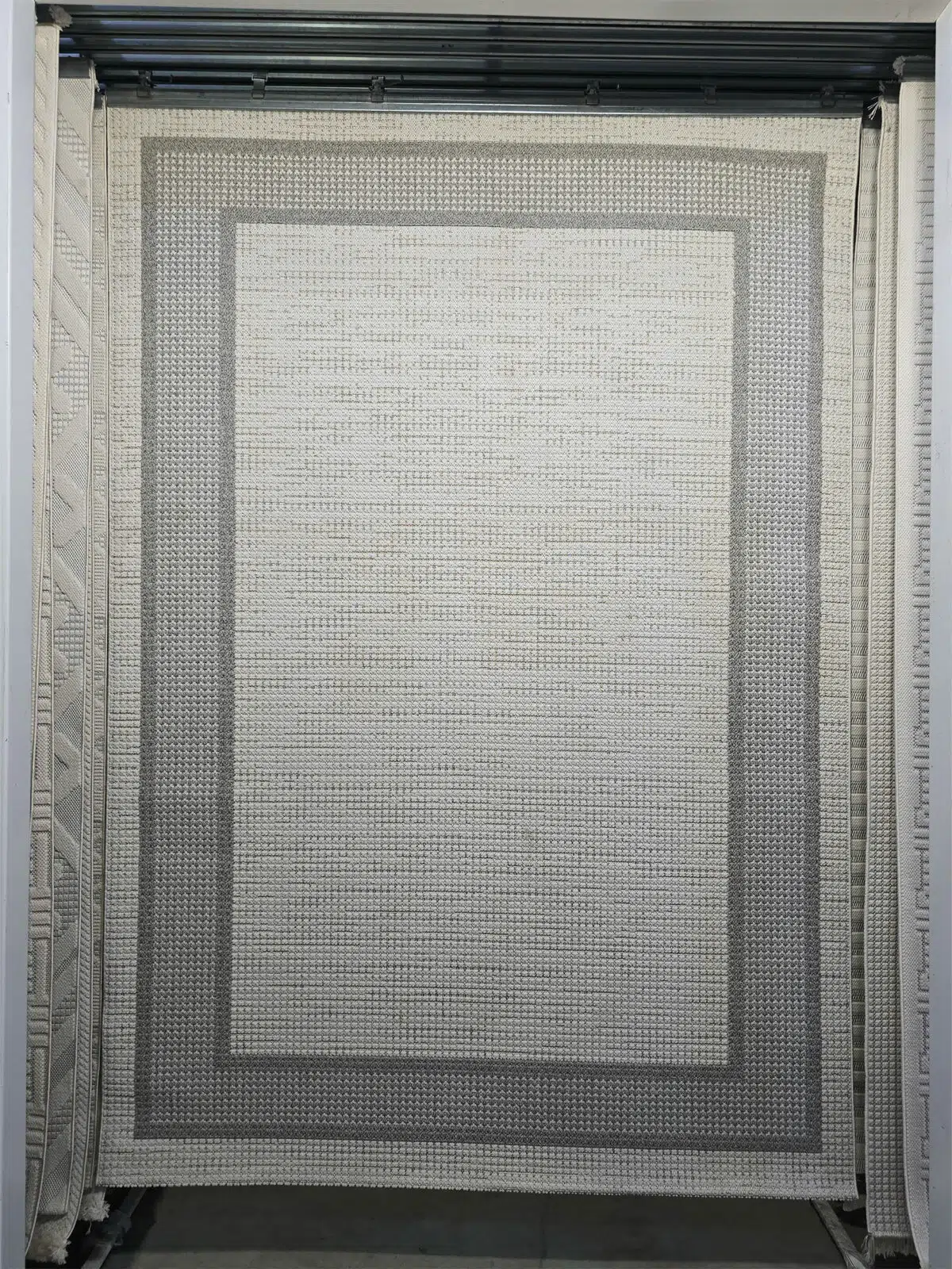 Entire front image of Juno carpet with dual grey border on cream base
