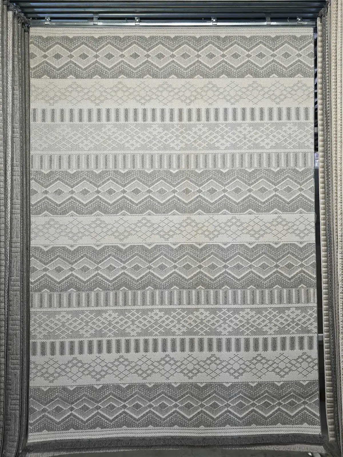 Hanging Nebulon rug featuring grey tribal and stripe patterns