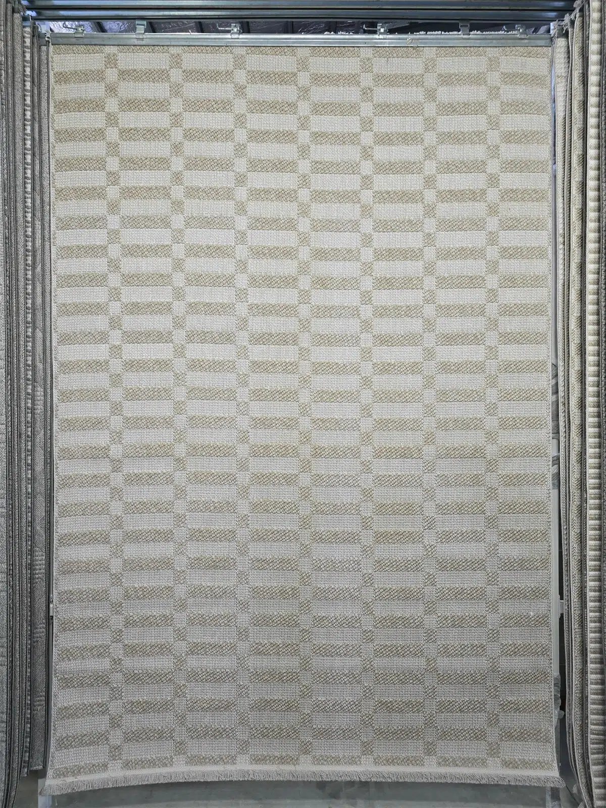 Beige and cream checkered rug with geometric pattern – Umbra design.