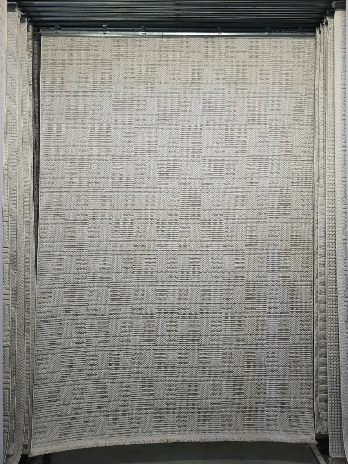 Full view of the Vortex rug showing geometric pattern in ivory and beige