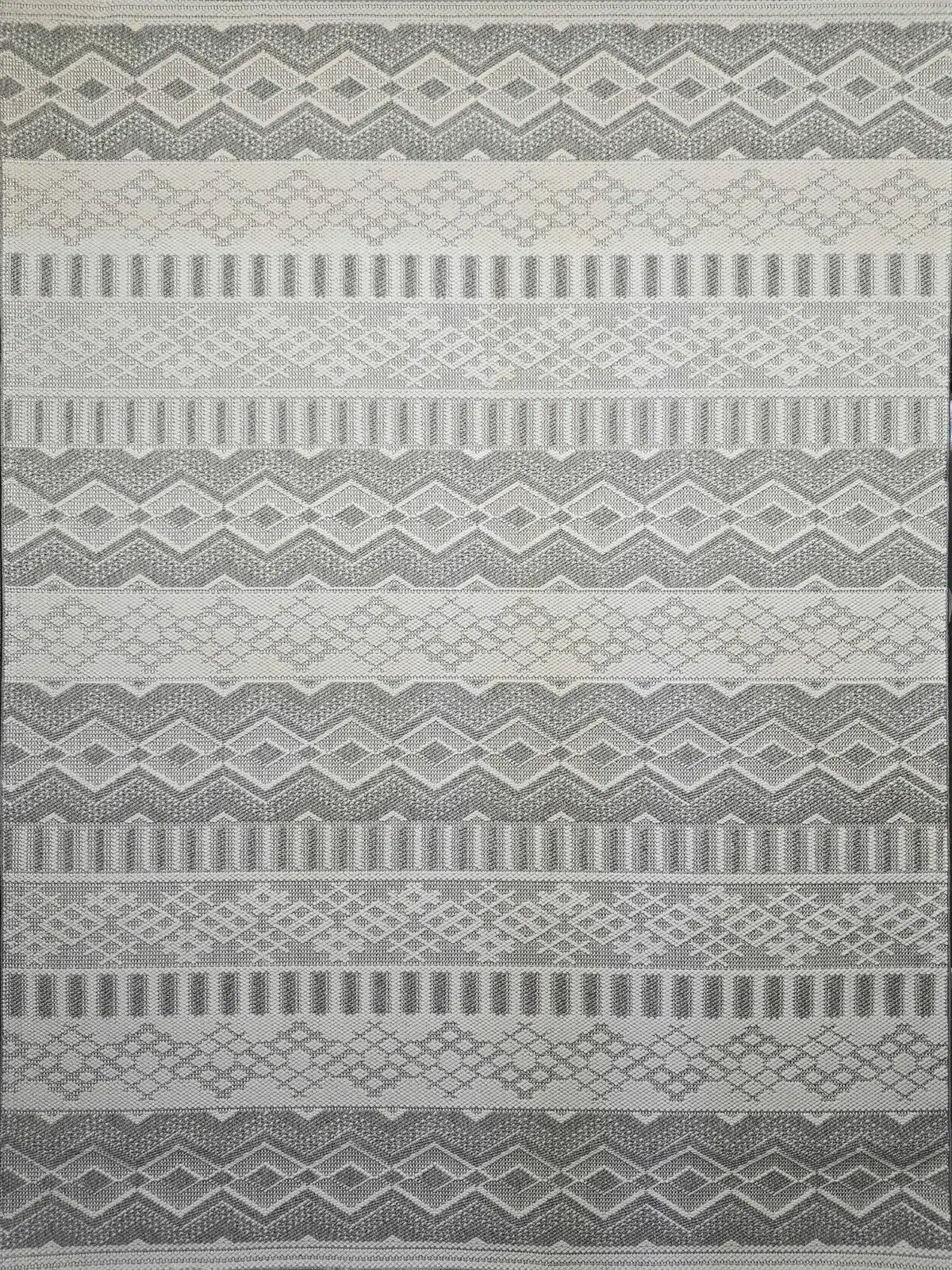Detailed shot of Nebulon rug’s grey and cream diamonds