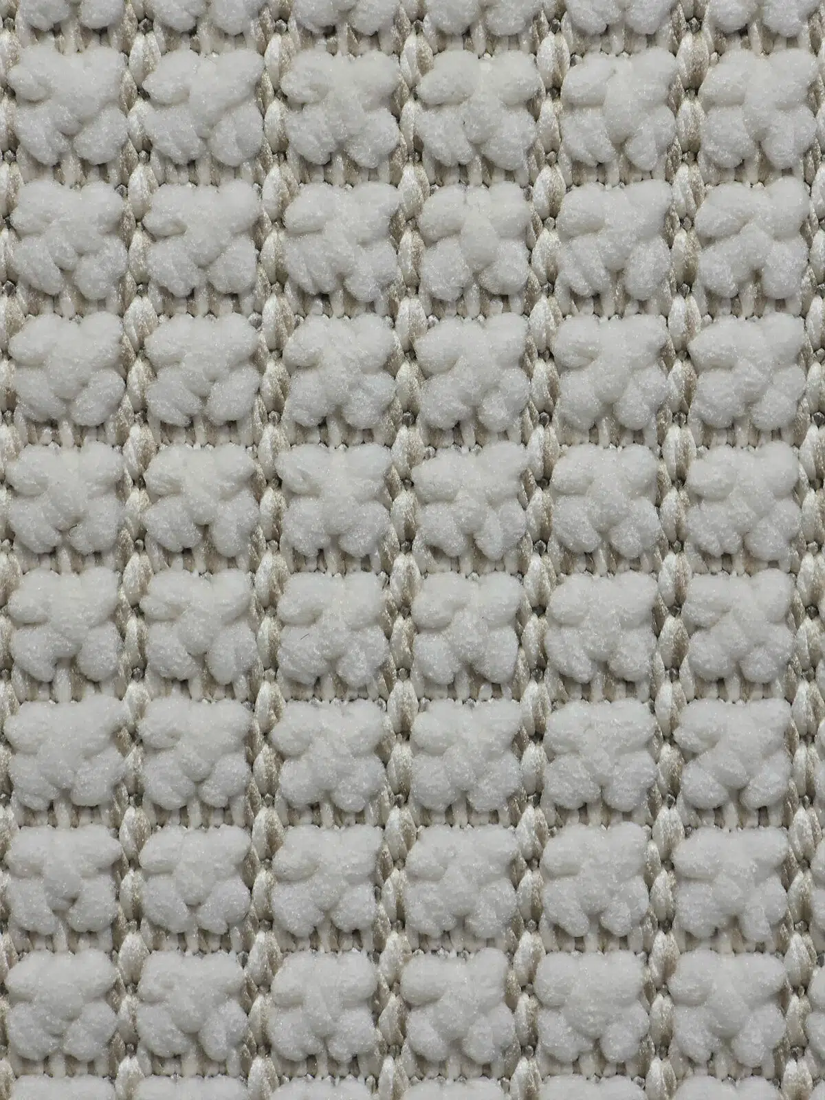 Close-up of Orbit rug fiber weave in soft white and beige