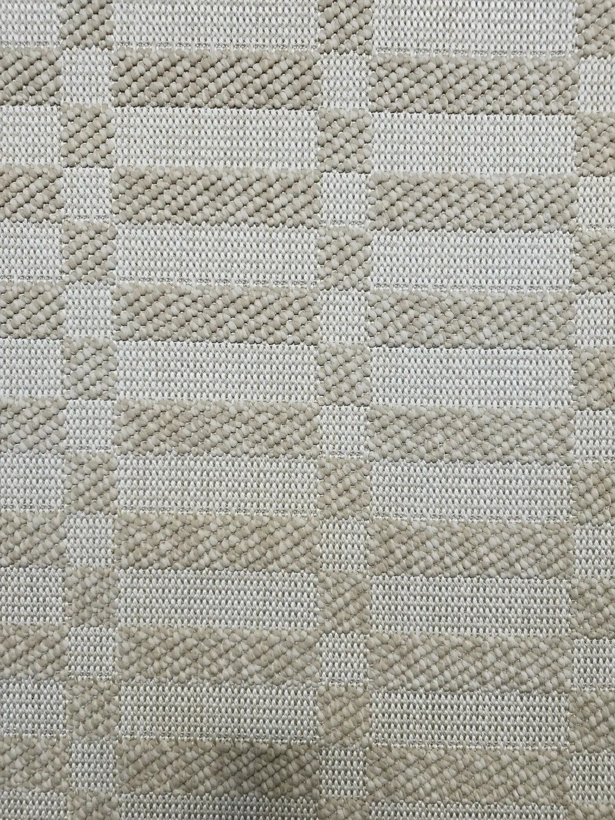 Close-up of Umbra rug’s texture and weave pattern in beige.