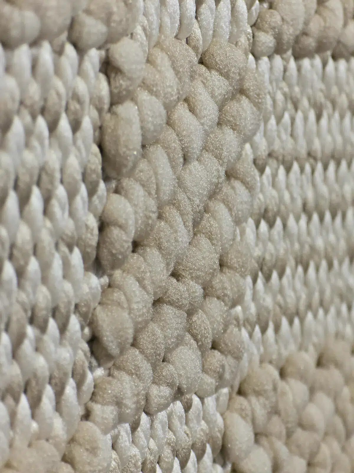 Soft beige fibers and tactile design of the Umbra carpet.
