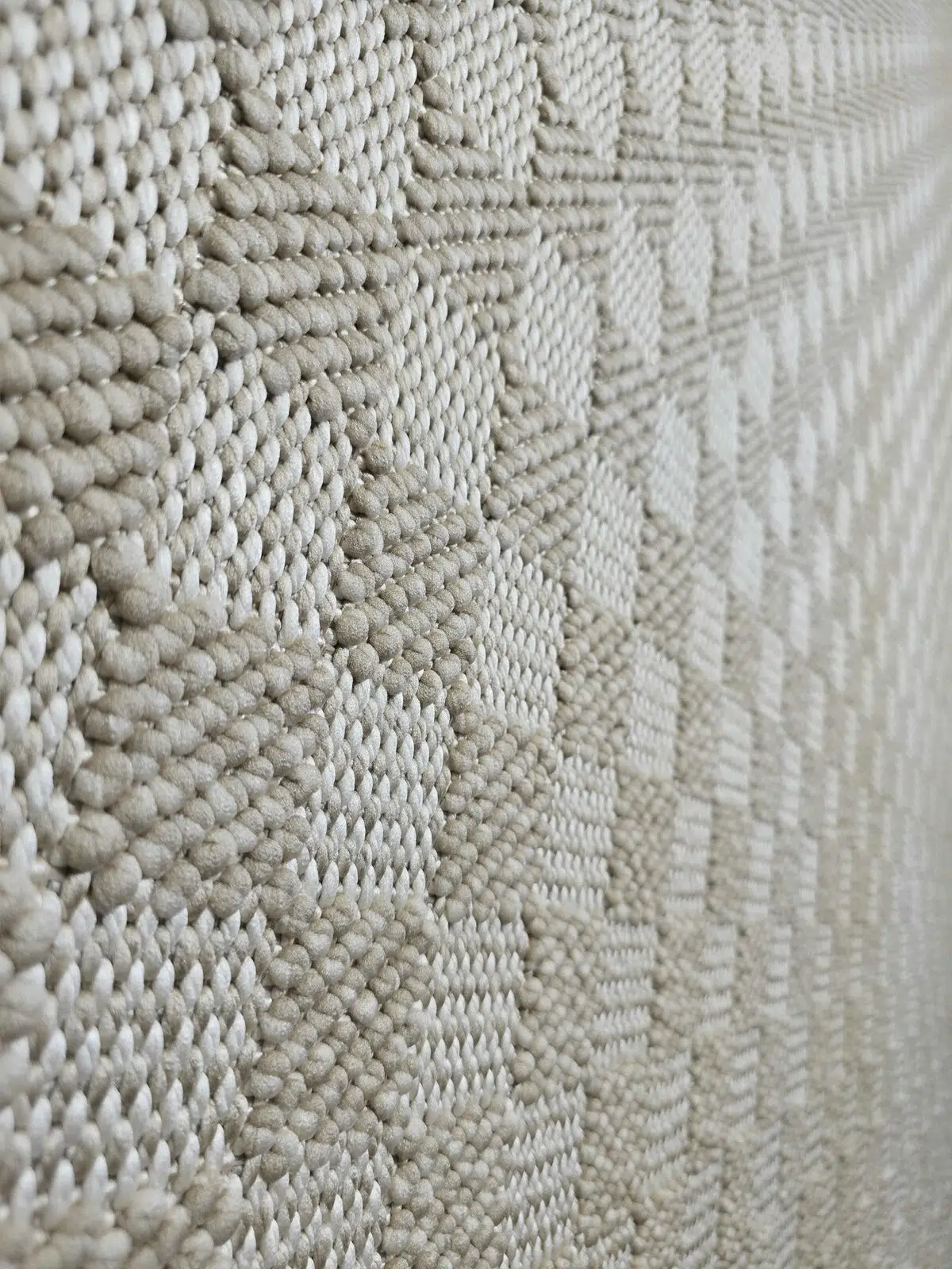 Angled closeup of Helios rug highlighting light beige fiber detailing