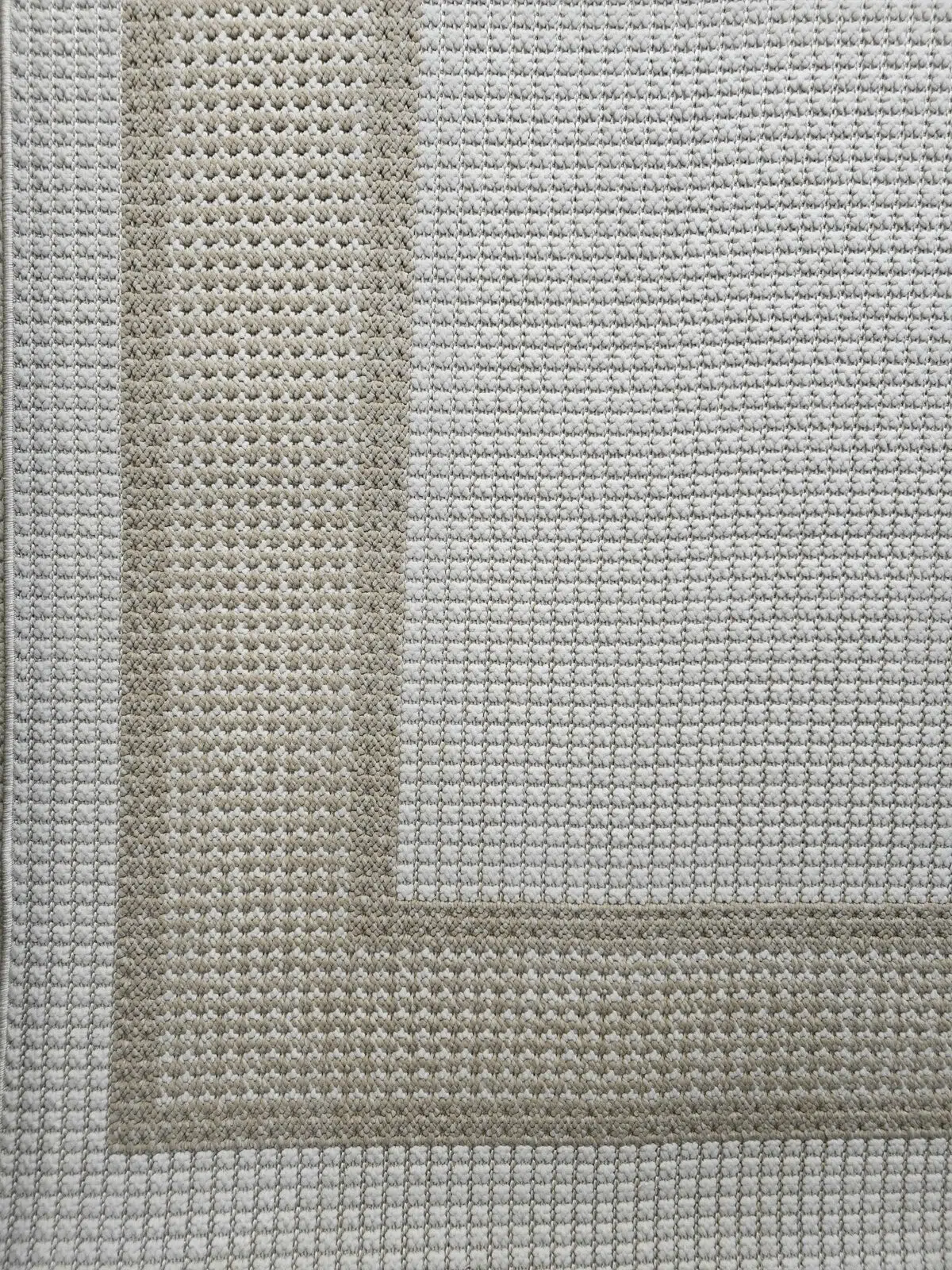 Orbit rug photo showing corner with double-line beige and white border