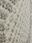 Close side view of Zephyr rug fibers in white and grey blend
