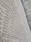 Rug’s backing with tight yarn weave and neutral tones