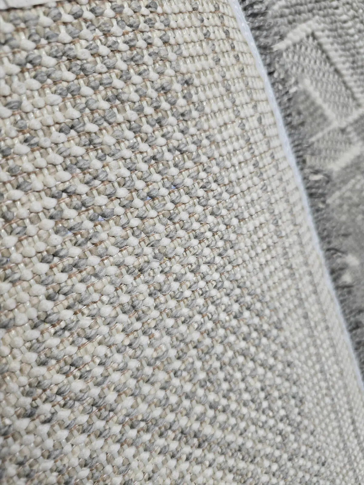 Rug’s backing with tight yarn weave and neutral tones